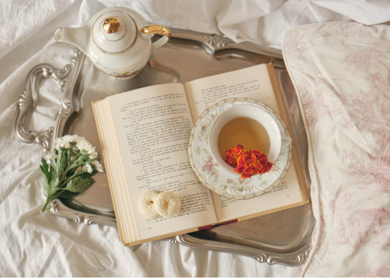 ベッドの上に本と紅茶が置いてある